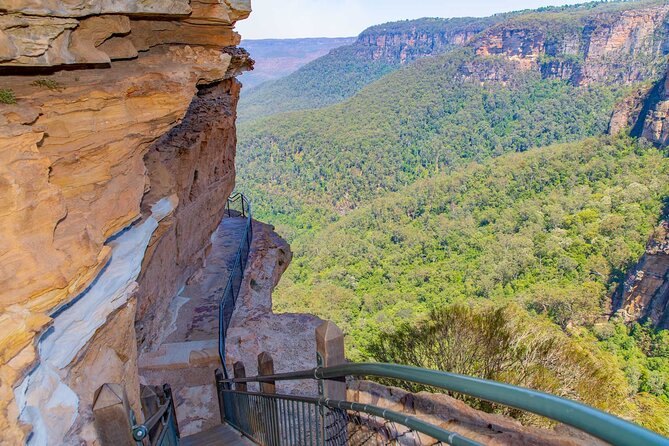 A walking track cut into the cliff edge with the valley open on one side