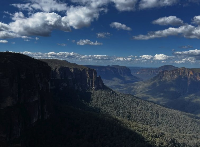 Cloud shadow moving across the sandstone escarpment and the valley below