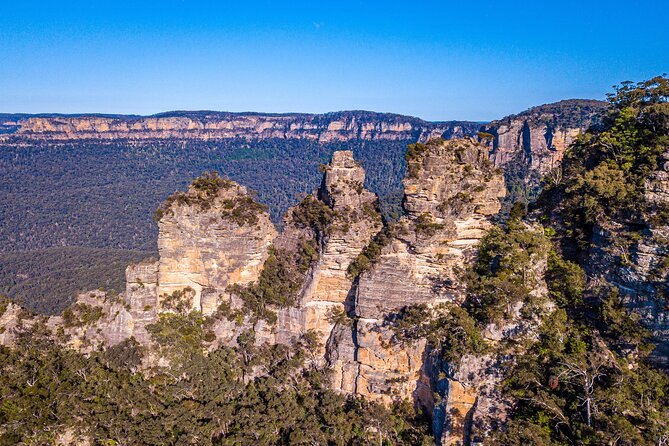 The Three Sisters from a clifftop railing, the valley dropping away below